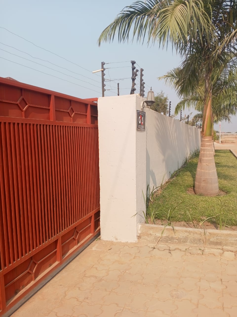 Terracotta entrance gate, ivory boundary wall and palm trees at the Mitengo furnished apartments in Ndola